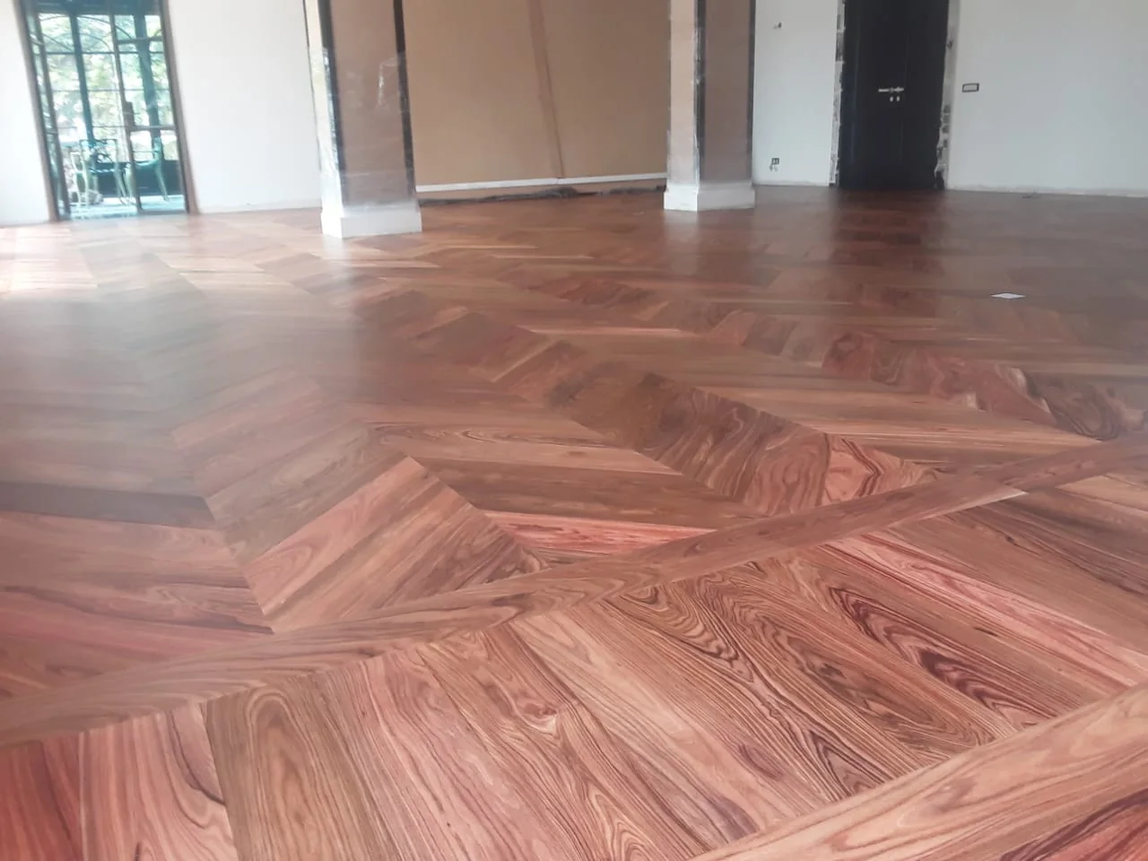 Vue d’ensemble du parquet en bâton rompu autour des piliers d’un séjour