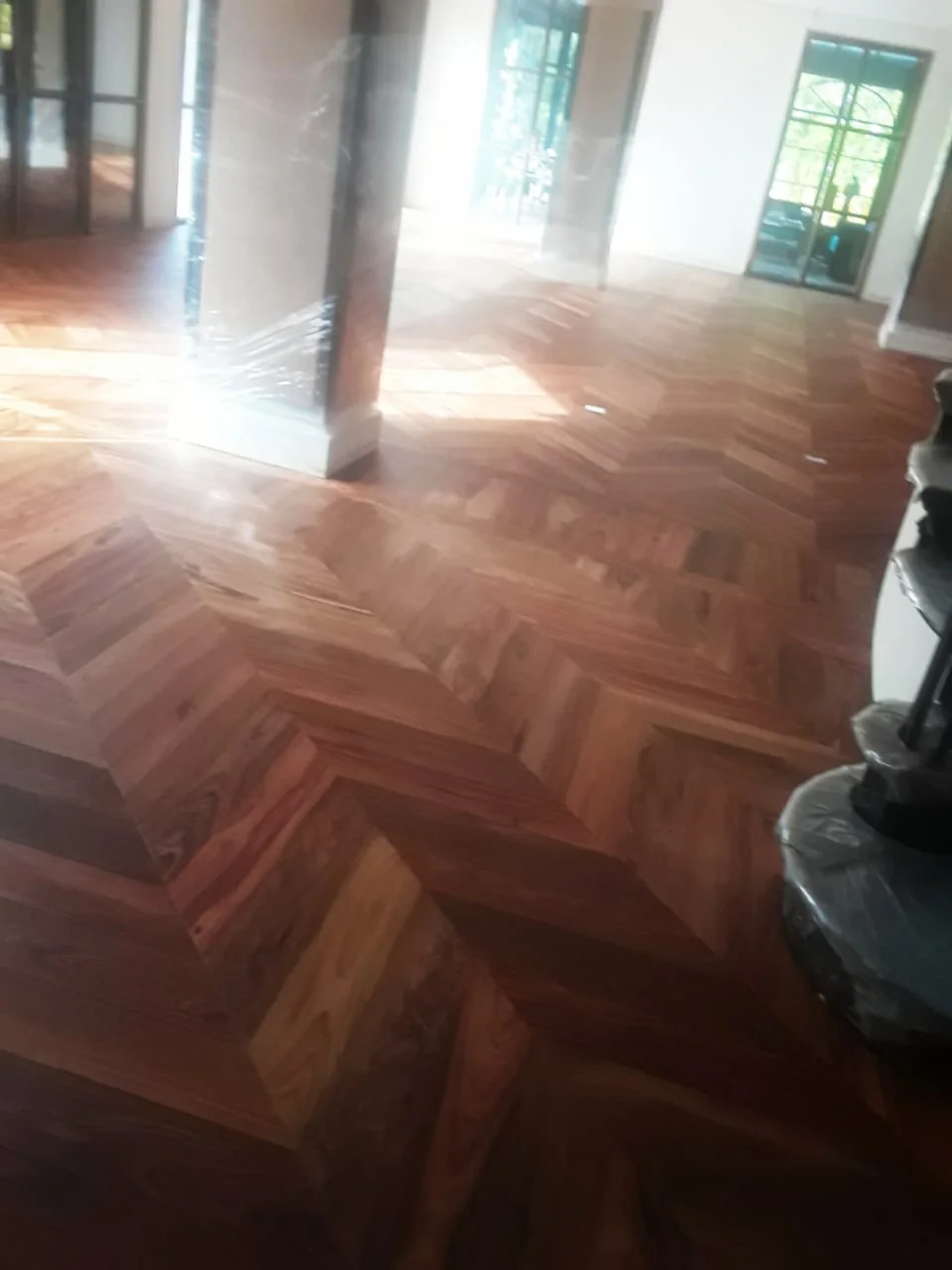 Parquet rouge brun en bâton rompu dans un séjour avec colonnes