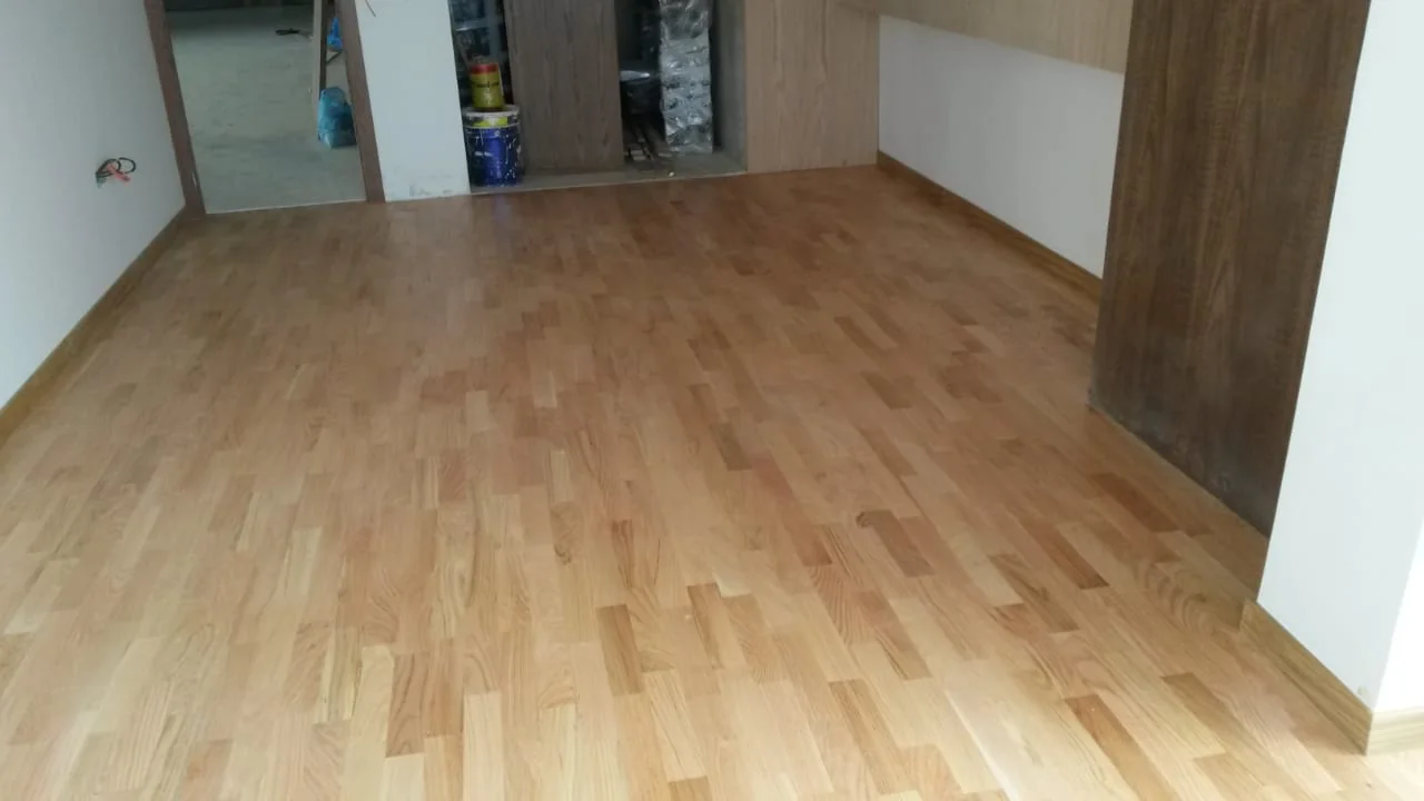 Parquet clair en pose droite dans une pièce ouverte sur une cuisine