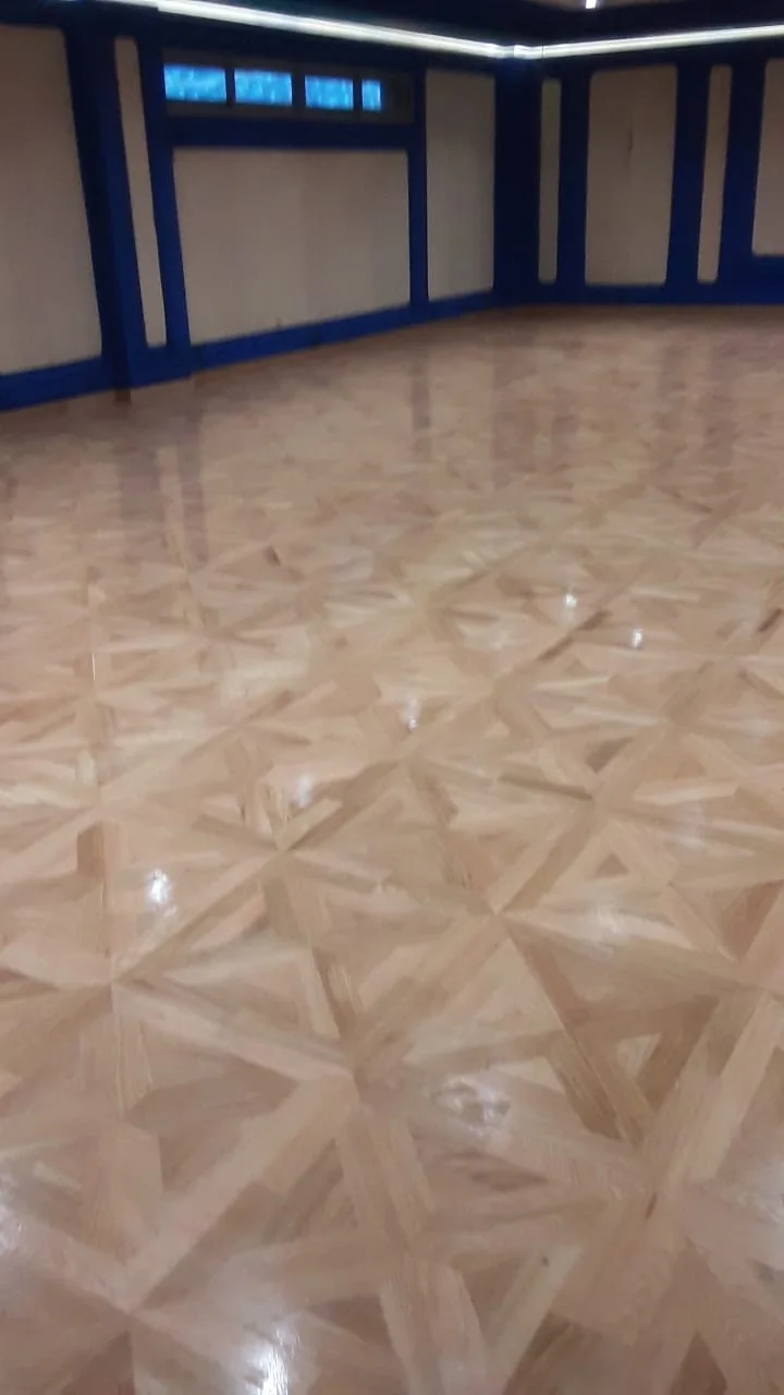 Perspective sur un parquet mosaïque avec reflets de fenêtres