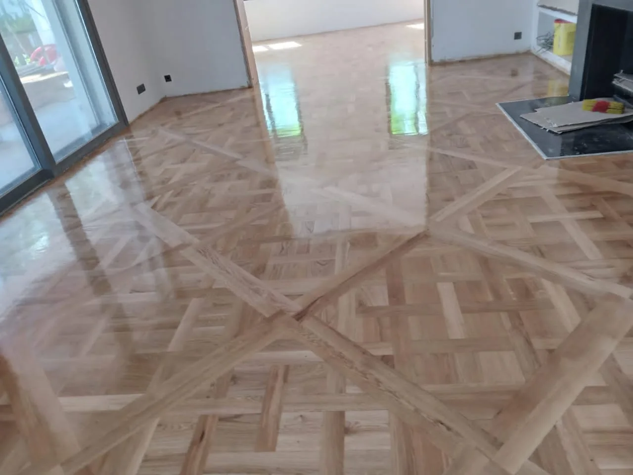 Parquet à motifs encadrés autour d’un pilier et près d’une baie vitrée