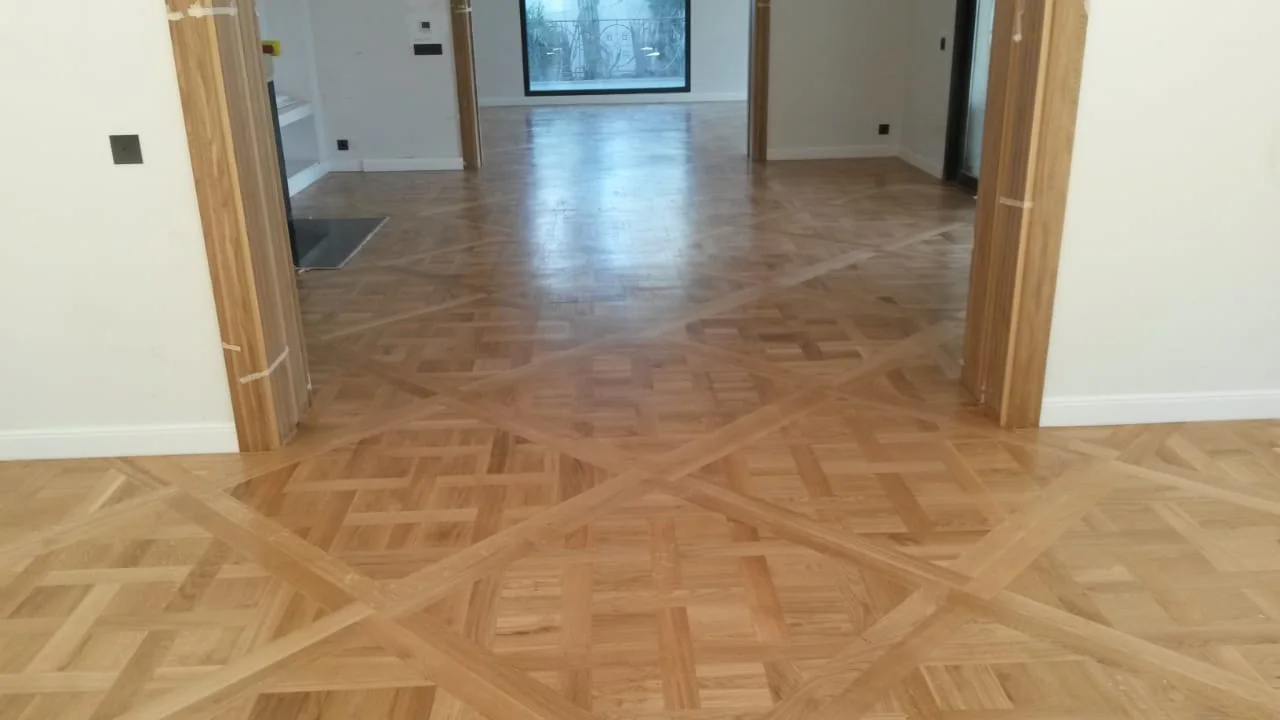Parquet clair à motifs géométriques entre deux pièces ouvertes