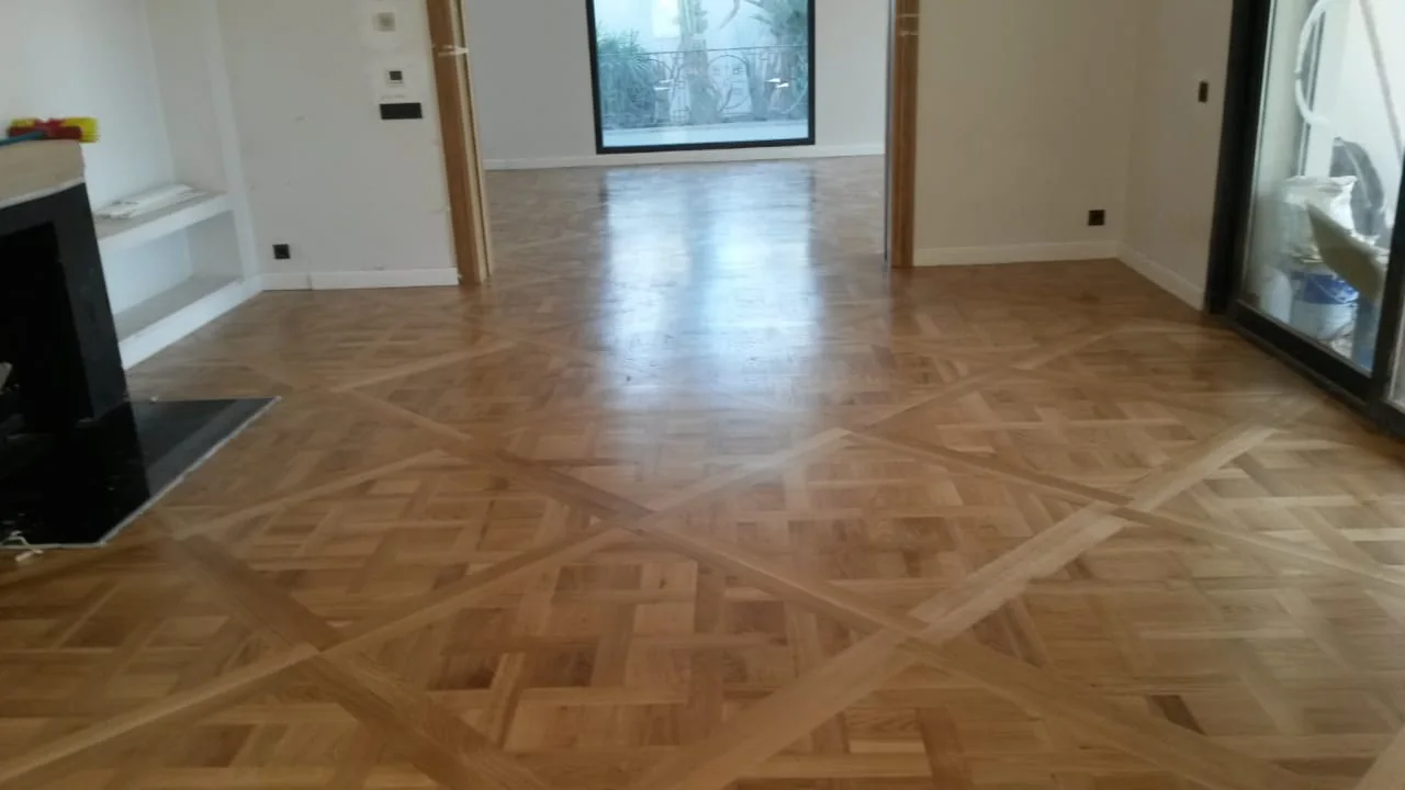 Vue du parquet à cadres géométriques dans un salon aux murs blancs