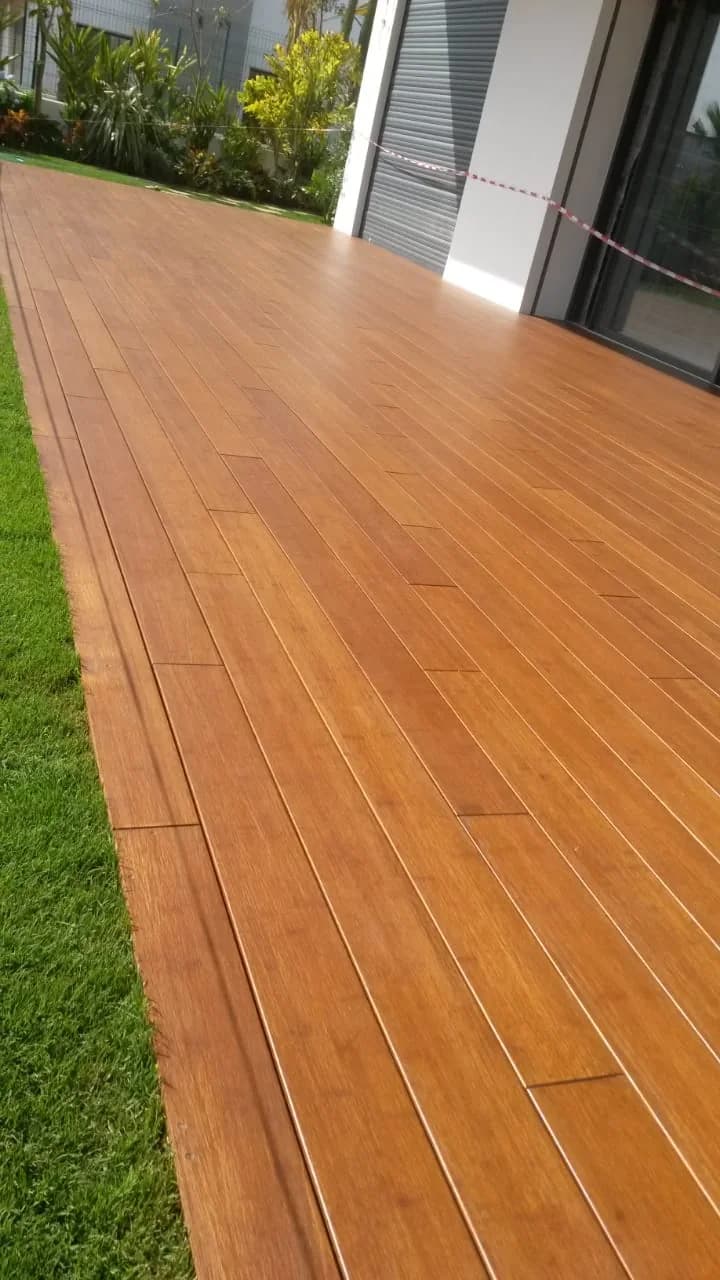 Platelage en bois le long d’une façade, entre la maison et le gazon